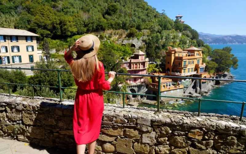 Woman in red dress enjoying coastal view in Italy